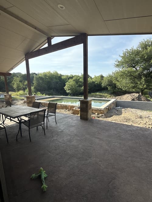 Bare ground and grade prepared around an existing pool before forming