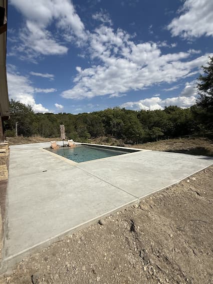 Completed stamped concrete pool deck under Texas sky