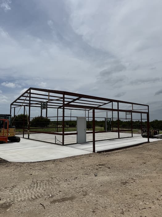 Bare steel frame standing on the finished concrete slab