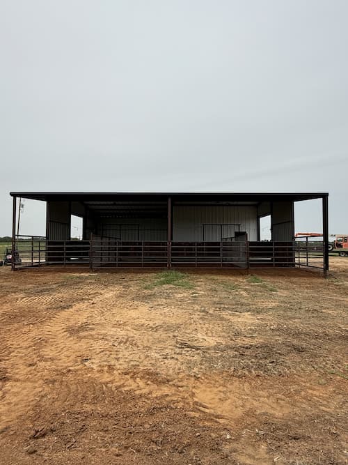 Finished white metal horse barn with wraparound covered runs