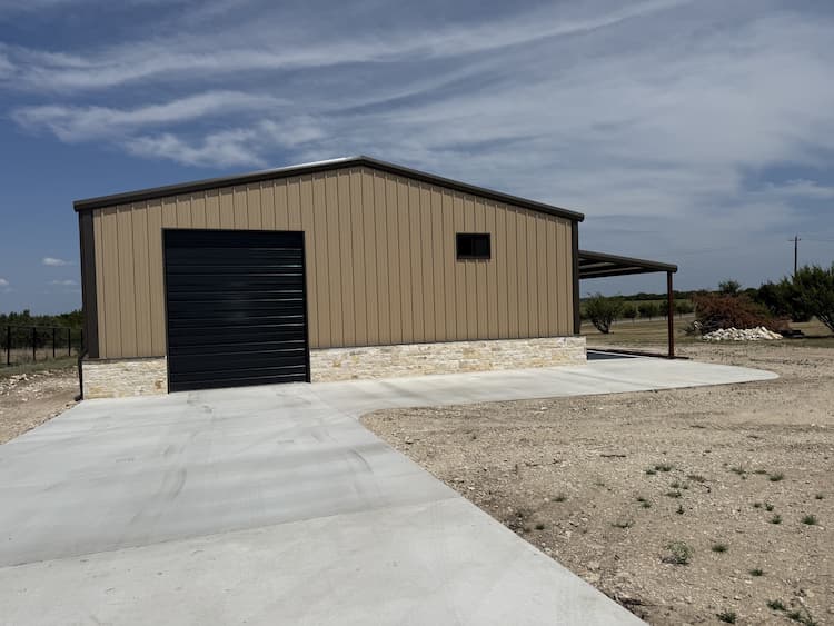 Finished metal shop with stone wainscot and covered patio
